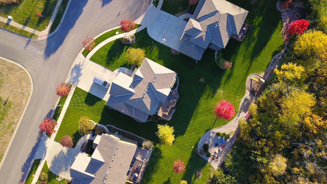 services-02 A picturesque aerial view showcasing suburban homes with vibrant gardens and tree-lined streets.